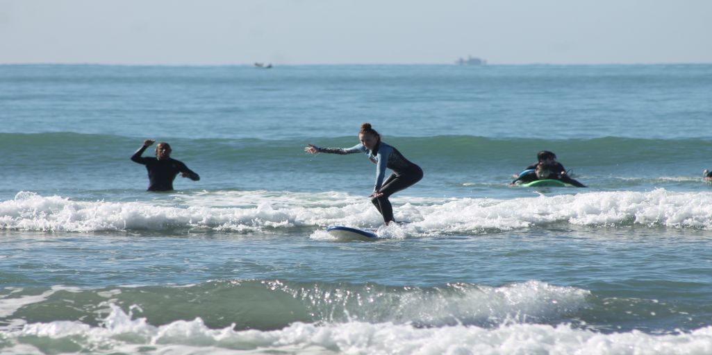 This Picture Shows the support and helping new surfers find confidence in the ocean as a part a surf trip