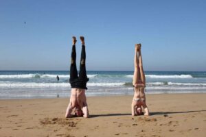 Edge of Comfort Zone: A couple doing handstands on the beach