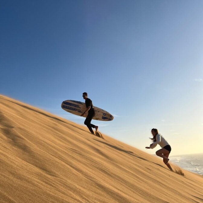 Climbing up the dune to sandboard