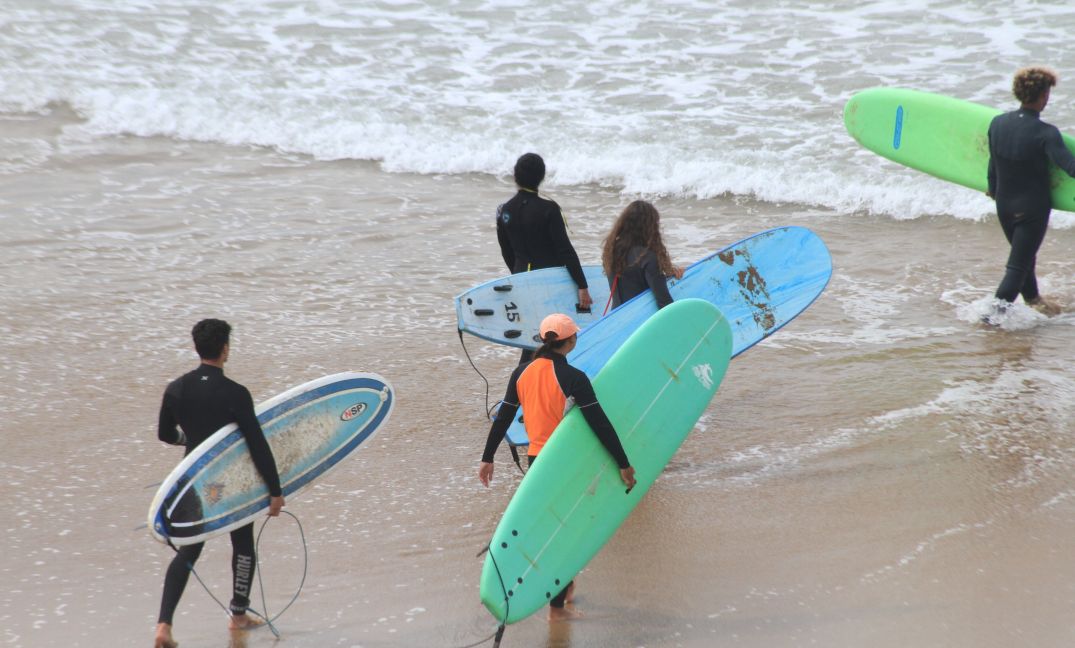 surfers walking to the ocean at sunrise surf camp Morocco cost experience