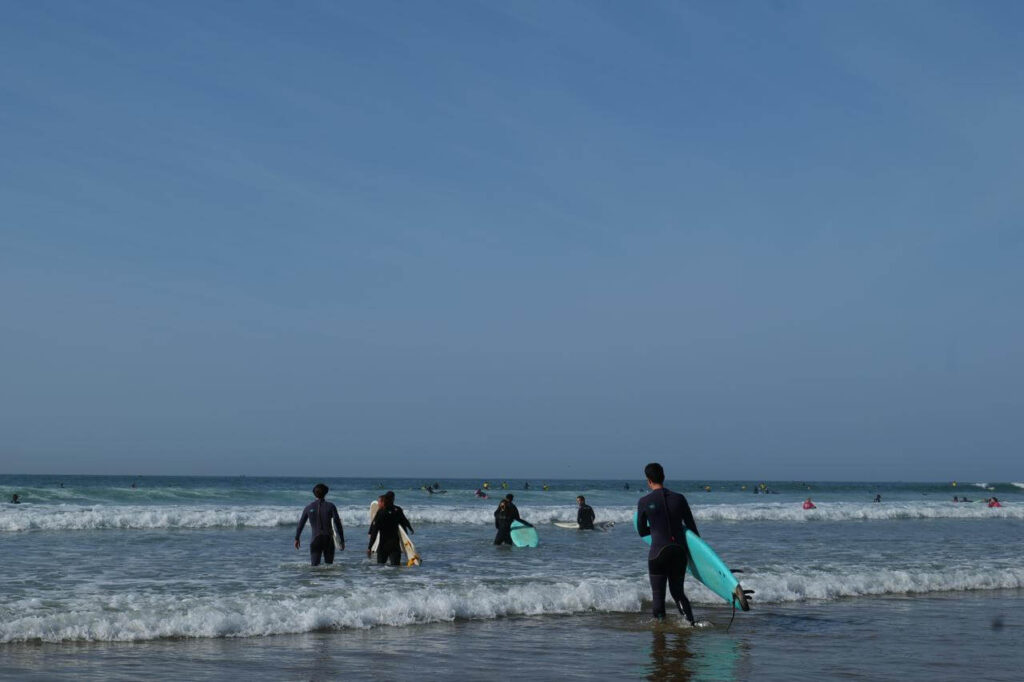 Surfer carrying surf boards in the beach