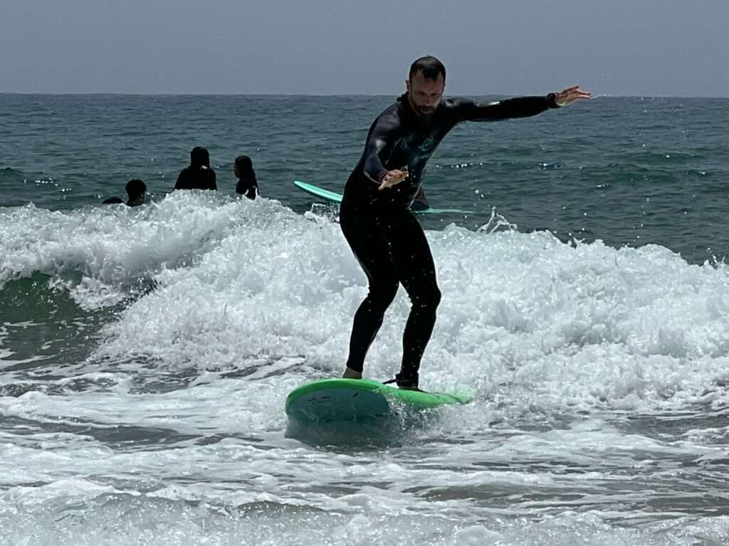 Student of Original Surf Morocco balancing himself while catching waves.