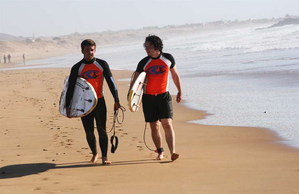 surfers walking on the beach by Original Surf Morocco